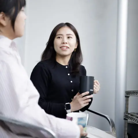 社内の女性二人がベランダで話している様子